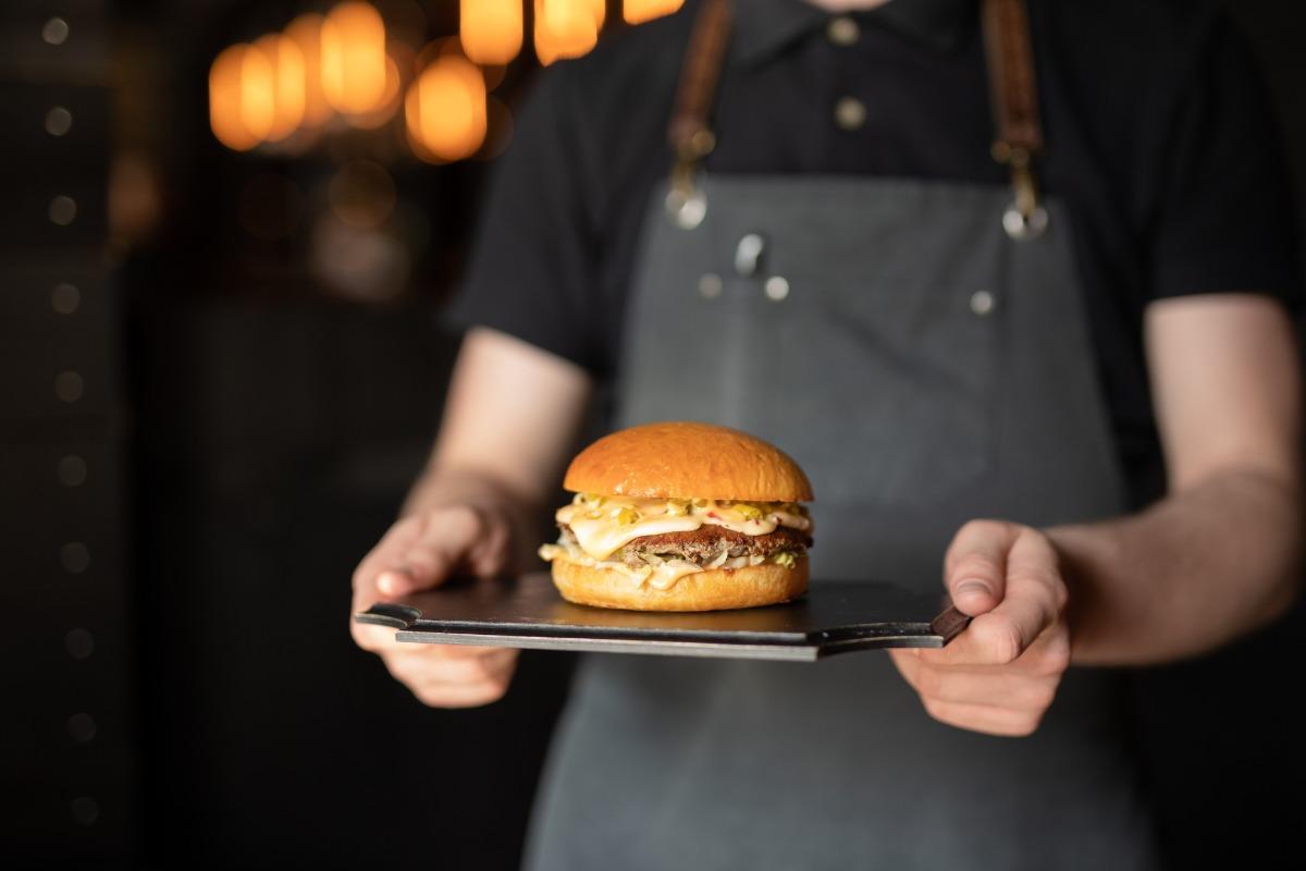 waiter bringing a hamburger to a family in a restaurant